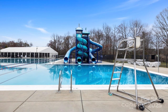 pool featuring fence, playground community, and a water slide