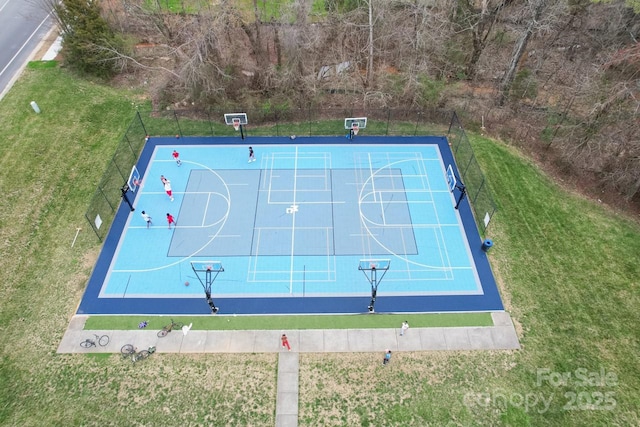 view of sport court with a lawn, community basketball court, and fence