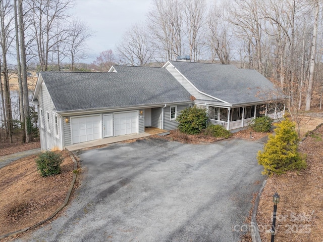 view of front of house featuring aphalt driveway, an attached garage, a chimney, and a shingled roof