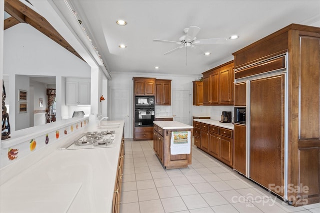 kitchen featuring a sink, black appliances, light tile patterned floors, and light countertops