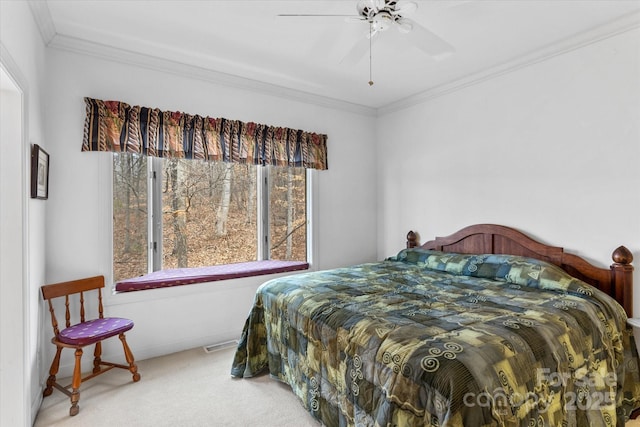 carpeted bedroom featuring visible vents, a ceiling fan, and crown molding