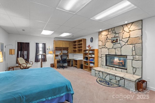 carpeted bedroom with a fireplace and a paneled ceiling