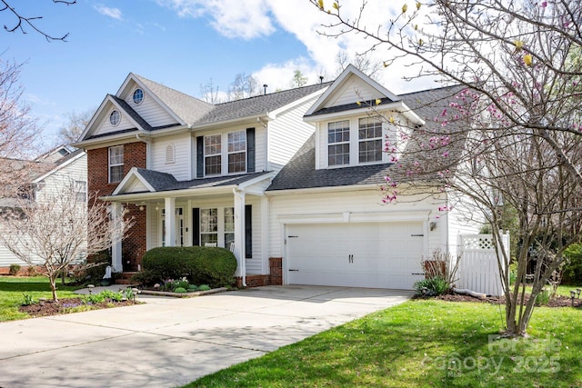 view of front of home featuring a front lawn, covered porch, roof with shingles, concrete driveway, and brick siding