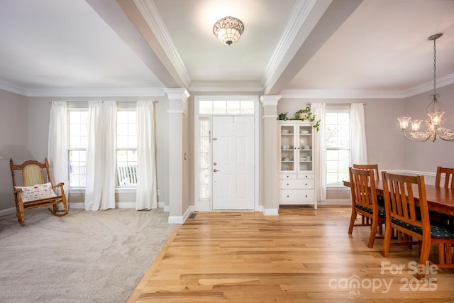 entryway featuring crown molding, light wood finished floors, and a chandelier