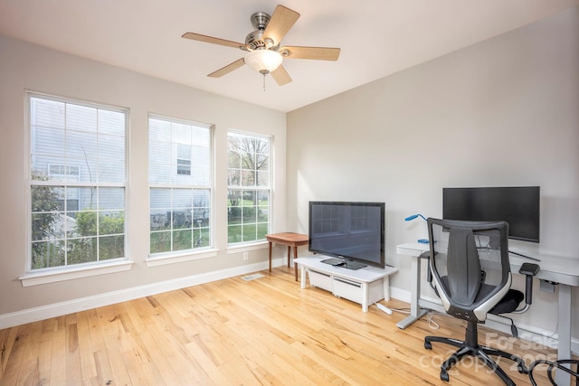 office featuring a ceiling fan, baseboards, and wood finished floors