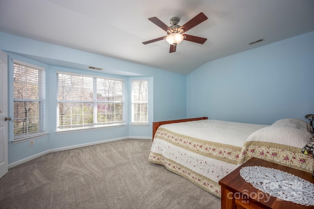 carpeted bedroom featuring lofted ceiling, baseboards, visible vents, and ceiling fan