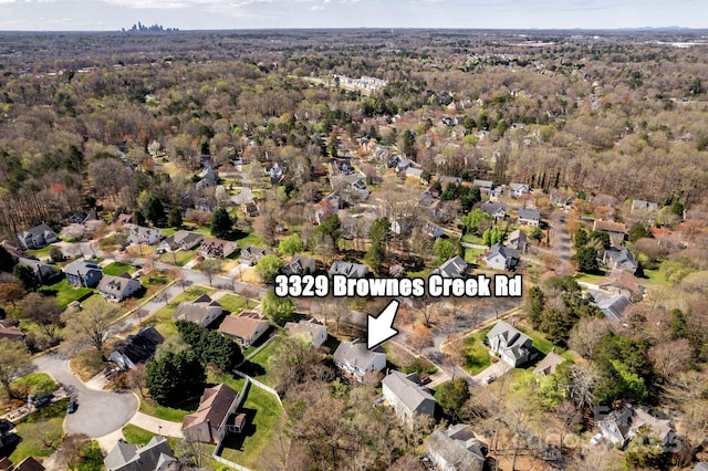 drone / aerial view with a forest view and a residential view