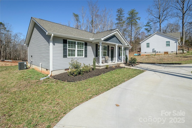 ranch-style home featuring a porch, cooling unit, roof with shingles, a front yard, and crawl space