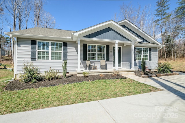 single story home featuring a porch, board and batten siding, and a front yard