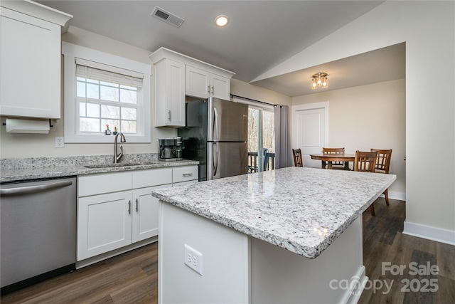 kitchen featuring visible vents, a sink, plenty of natural light, appliances with stainless steel finishes, and vaulted ceiling