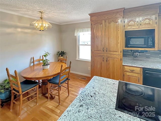 dining space with visible vents, ornamental molding, a textured ceiling, light wood-type flooring, and a chandelier