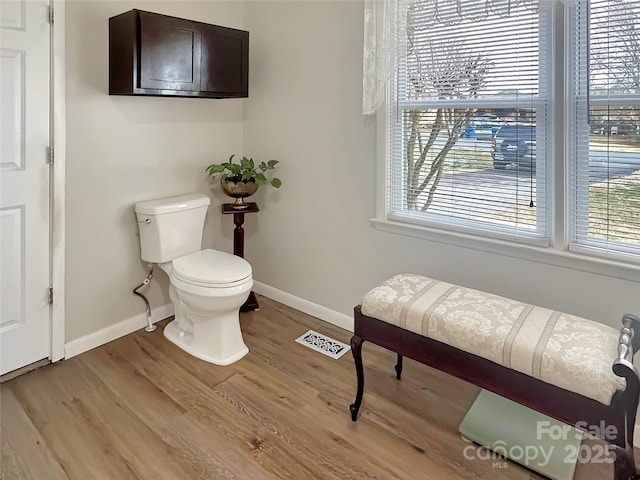 bathroom featuring visible vents, toilet, wood finished floors, and baseboards