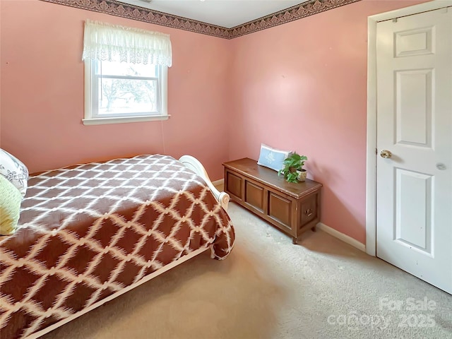 bedroom with light colored carpet and baseboards