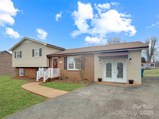 tri-level home with crawl space, french doors, a front lawn, and brick siding