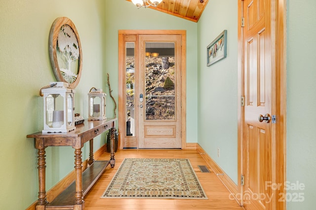 entrance foyer with lofted ceiling, light wood-style floors, visible vents, and baseboards