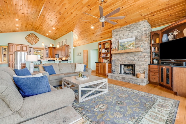 living area featuring high vaulted ceiling, light wood-style flooring, recessed lighting, a stone fireplace, and wooden ceiling