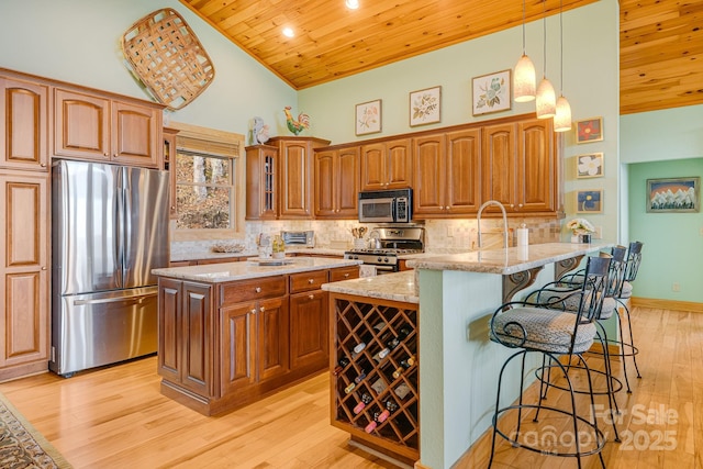 kitchen featuring wood ceiling, a kitchen breakfast bar, high vaulted ceiling, and appliances with stainless steel finishes