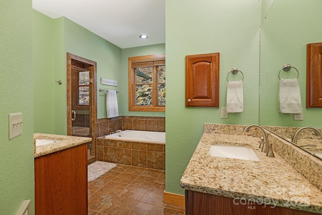 bathroom with tile patterned flooring, a garden tub, two vanities, a stall shower, and a sink