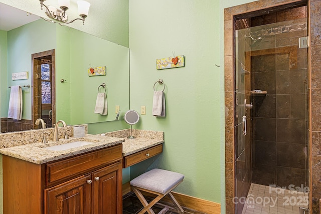 bathroom with baseboards, a stall shower, and vanity