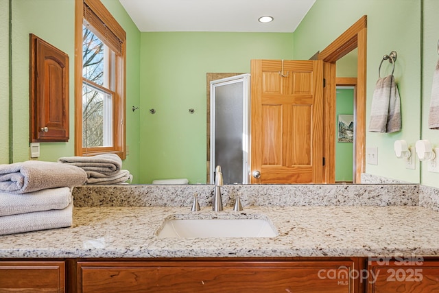 bathroom featuring toilet, a stall shower, and vanity