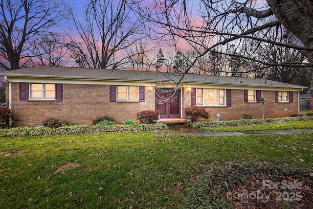 single story home featuring a front yard and brick siding