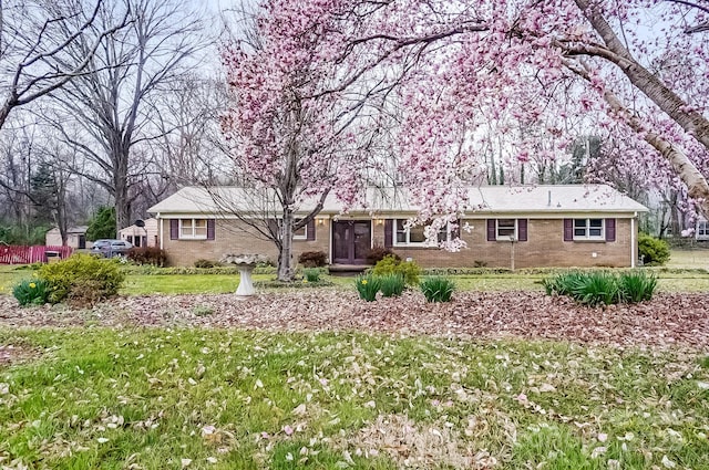 ranch-style home with brick siding and a front yard