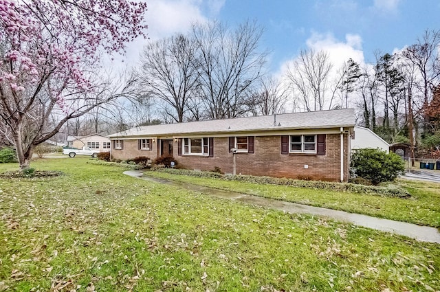 view of front of house featuring brick siding and a front yard