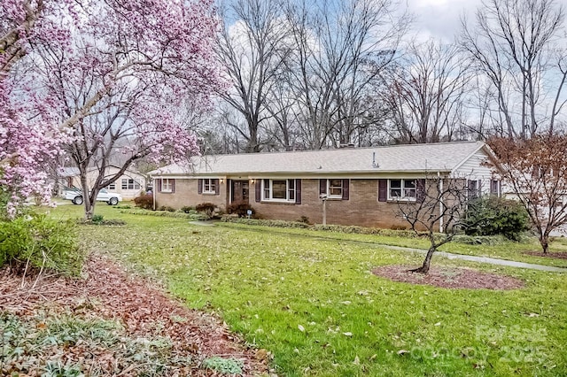 view of front of property featuring brick siding and a front lawn