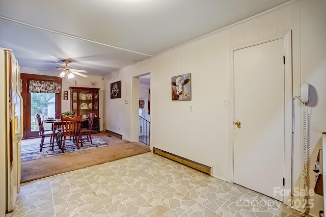 unfurnished dining area with light colored carpet, baseboard heating, and a ceiling fan