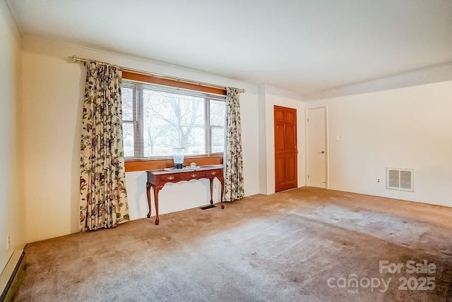 unfurnished room featuring visible vents, a baseboard radiator, and carpet floors