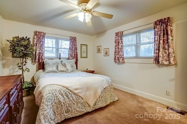 carpeted bedroom with ceiling fan and baseboards