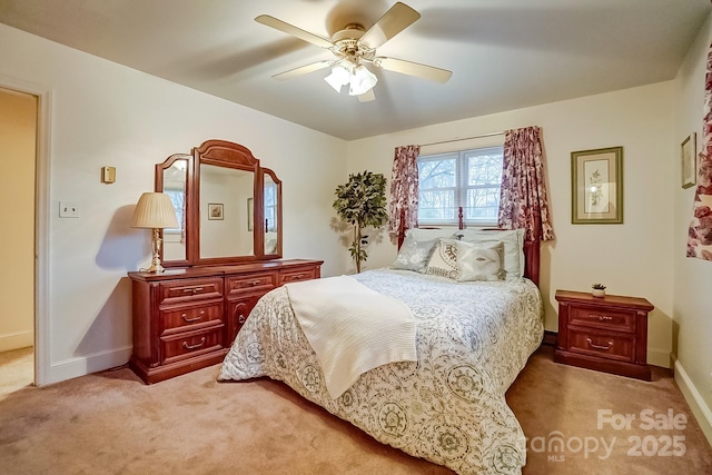 bedroom with light colored carpet, baseboards, and ceiling fan