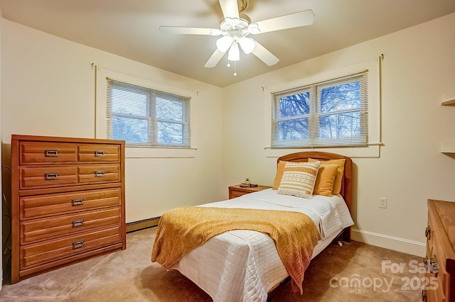 bedroom with a ceiling fan, light colored carpet, baseboards, and a baseboard heating unit