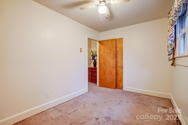 unfurnished room featuring carpet flooring, baseboards, and ceiling fan