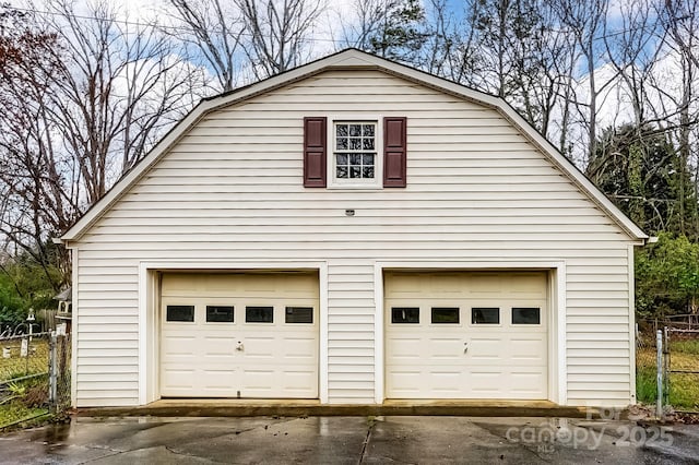 garage with a detached garage and fence