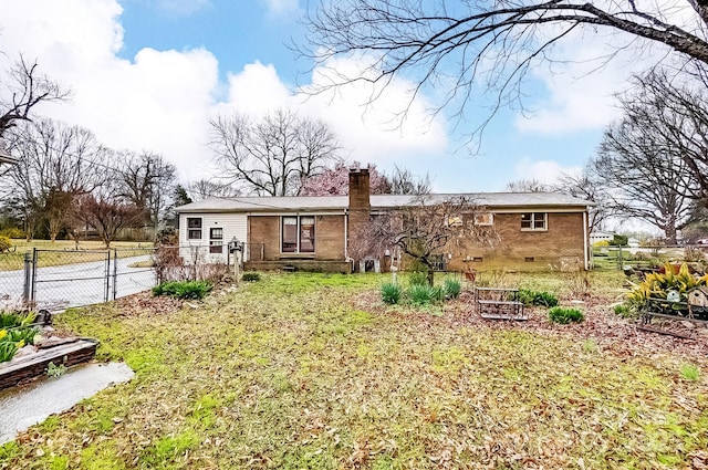 back of house featuring brick siding, fence, a chimney, crawl space, and a gate