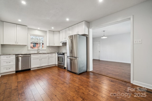 kitchen with a sink, dark wood finished floors, white cabinetry, and stainless steel appliances