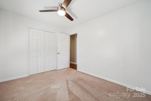 unfurnished bedroom featuring a closet, carpet flooring, a ceiling fan, and baseboards