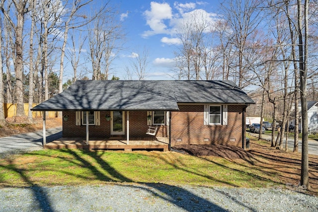 view of front of property featuring roof with shingles, driveway, a front lawn, crawl space, and brick siding