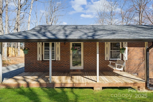 rear view of property with brick siding and roof with shingles