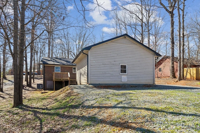 view of home's exterior featuring brick siding and a deck