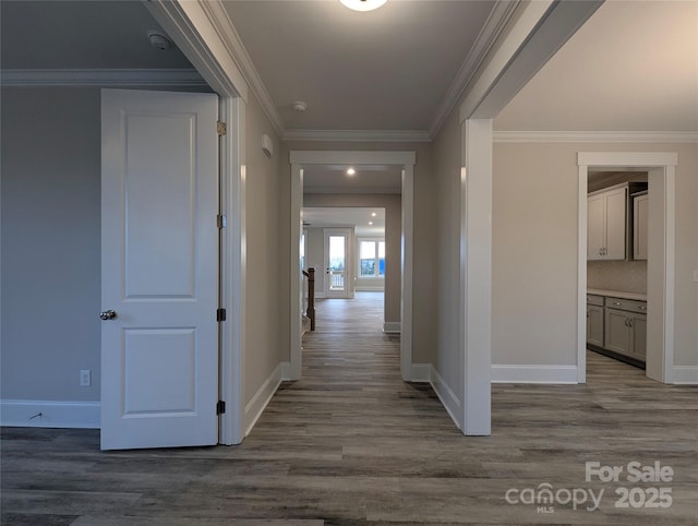 hallway with dark wood-style floors, baseboards, and ornamental molding