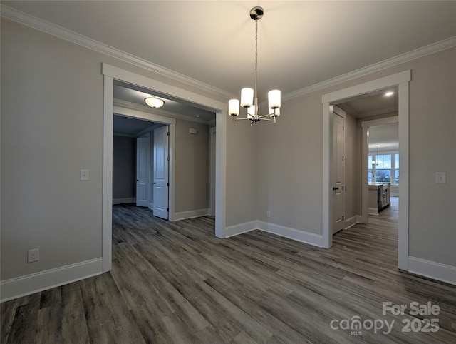 unfurnished dining area with crown molding, a notable chandelier, wood finished floors, and baseboards