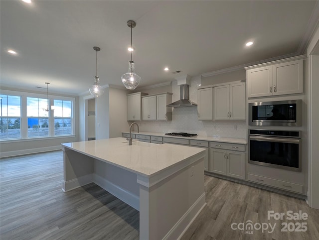 kitchen featuring ornamental molding, wall chimney range hood, backsplash, appliances with stainless steel finishes, and light countertops