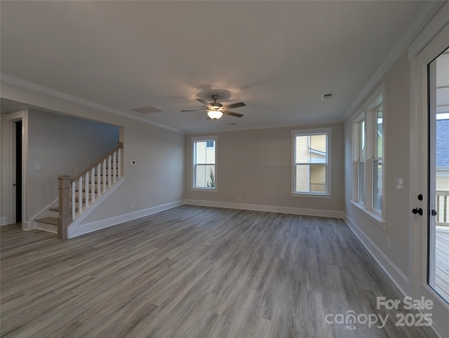 unfurnished living room featuring crown molding, stairway, wood finished floors, and visible vents