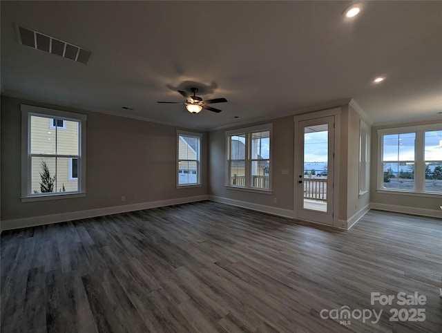 interior space with visible vents, dark wood-style flooring, baseboards, and ornamental molding