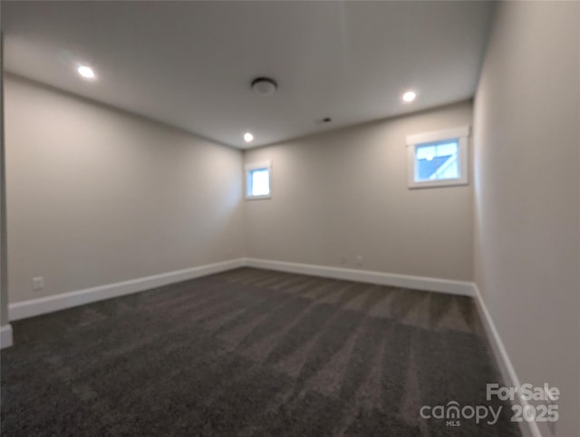 spare room with recessed lighting, baseboards, and dark colored carpet