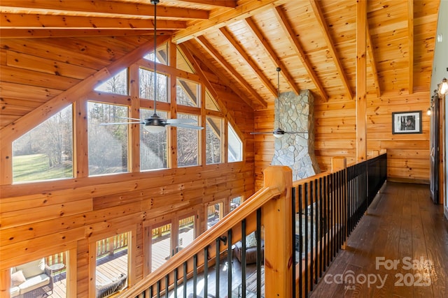 corridor featuring beamed ceiling, high vaulted ceiling, wood-type flooring, wood walls, and wood ceiling