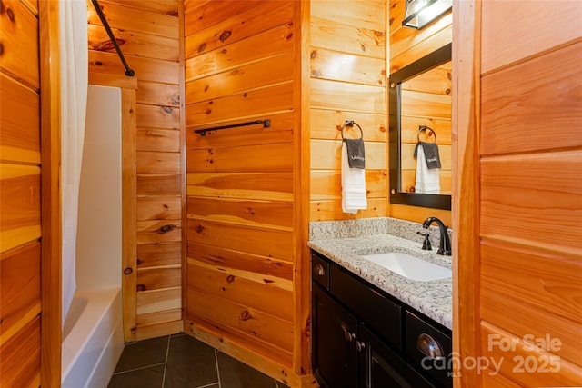 bathroom featuring tile patterned floors, wood walls, and vanity