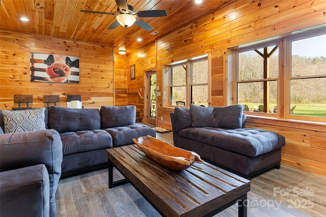 living room with recessed lighting, wood finished floors, wooden ceiling, and wood walls